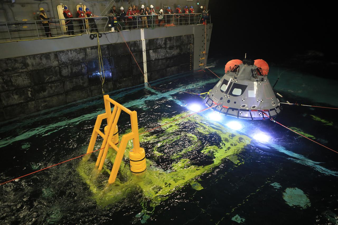 At night, on Nov. 1, 2018, a test version of the Orion capsule is pulled into the well deck of the USS John P. Murtha during Underway Recovery Test-7 (URT) in the Pacific Ocean. URT-7 is one in a series of tests conducted by the Exploration Ground Systems Recovery Team to verify and validate procedures and hardware that will be used to recover the Orion spacecraft after it splashes down in the Pacific Ocean following deep space exploration missions. Orion will have emergency abort capability, sustain the crew during space travel and provide safe re-entry from deep space return velocities.