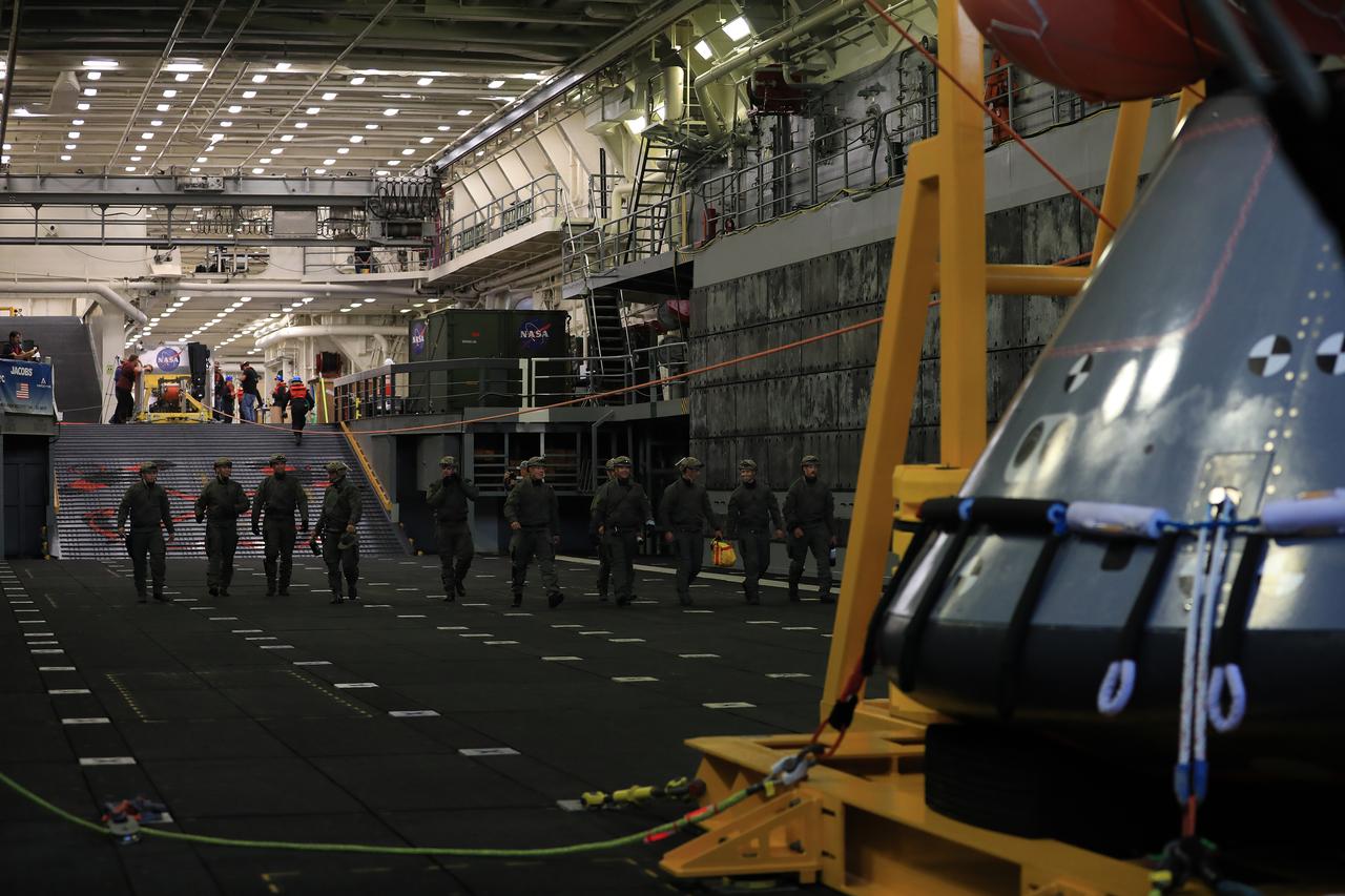 U.S. Navy divers prepare for night operations on Nov. 3, 2018, during Underway Recovery Test-7 (URT-7) in the well deck of the USS John P. Murtha. NASA's Recovery Team is testing to verify and validate procedures and hardware that will be used to recover the Orion spacecraft after it splashes down in the Pacific Ocean following deep space exploration missions. Orion will have emergency abort capability, sustain the crew during space travel and provide safe re-entry from deep space return velocities.
