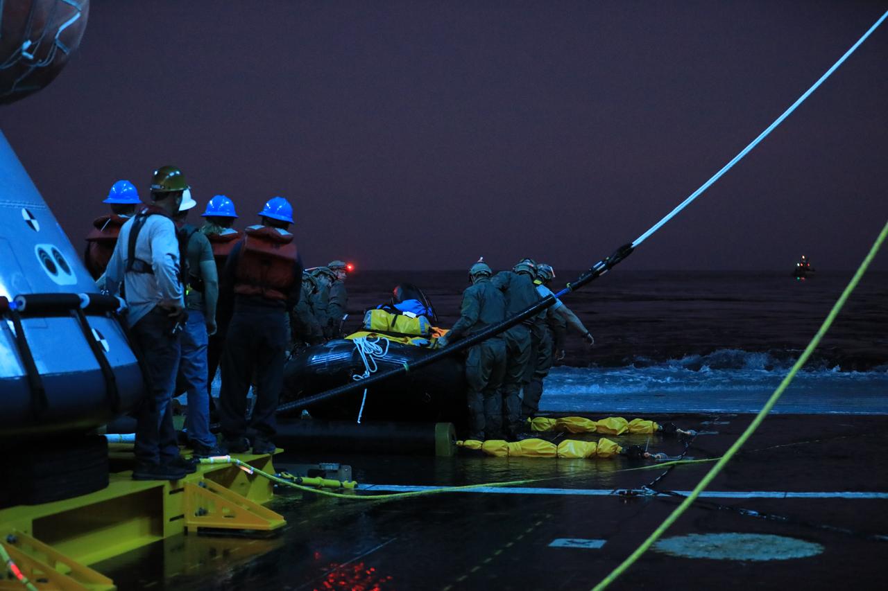 U.S. Navy divers prepare for night operations on Nov. 3, 2018, during Underway Recovery Test-7 (URT-7) in the well deck of the USS John P. Murtha. NASA's Recovery Team is testing to verify and validate procedures and hardware that will be used to recover the Orion spacecraft after it splashes down in the Pacific Ocean following deep space exploration missions. Orion will have emergency abort capability, sustain the crew during space travel and provide safe re-entry from deep space return velocities.