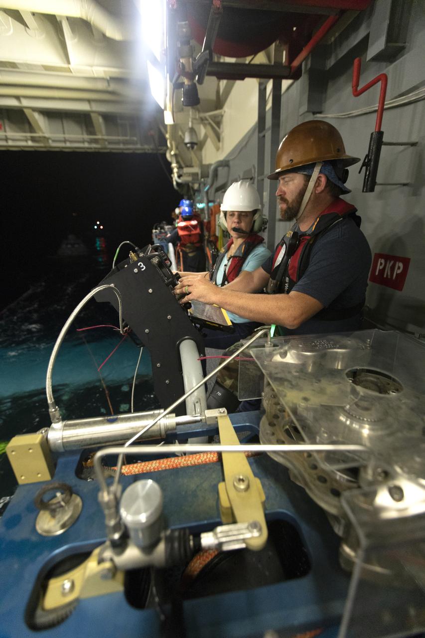 NASA Recovery Team members assist during Underway Recovery Test-7 (URT-7) inside the well deck of the USS John P. Murtha on Nov. 4, 2018. During URT-7, the team practices recovering a test version of the Orion capsule from the Pacific Ocean and towing it into the well deck of the ship. URT-7 is one in a series of tests conducted by the Exploration Ground Systems Recovery Team to verify and validate procedures and hardware that will be used to recover the Orion spacecraft after it splashes down in the Pacific Ocean following deep space exploration missions. Orion will have emergency abort capability, sustain the crew during space travel and provide safe re-entry from deep space return velocities.