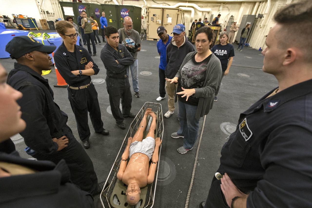 NASA and U.S. Navy recovery team members go over procedures for bringing an astronaut aboard, using a dummy, during Underway Recovery Test 7 aboard the USS John P. Murtha on Nov. 5, 2018. The Recovery Team is practicing recovery of the Orion capsule as part of URT-7 in the Pacific Ocean. URT-7 is one in a series of tests to verify and validate procedures and hardware that will be used to recover the Orion spacecraft after it splashes down in the Pacific Ocean following deep space exploration missions. Orion will have emergency abort capability, sustain the crew during space travel and provide safe re-entry from deep space return velocities.