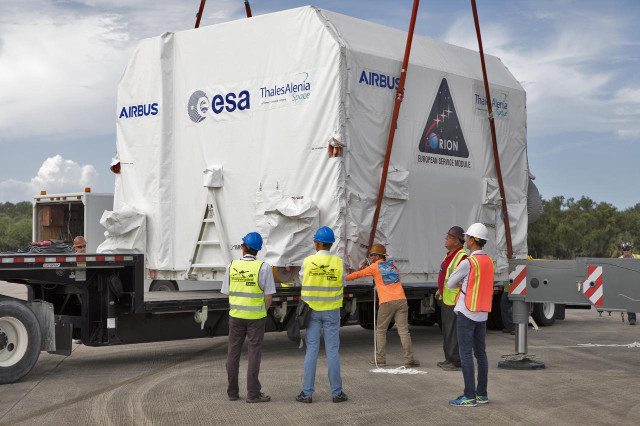 A crane lowers the shipping container holding the European Service Module (ESM) onto a flatbed truck at the Shuttle Landing Facility at NASA's Kennedy Space Center in Florida on Nov. 6, 2018. The ESM, built by the European Space Agency, will supply the main propulsion system and power to the Orion spacecraft for Exploration Mission-1 (EM-1), a mission to the Moon. The ESM also will house air and water for astronauts on future missions. EM-1 will be an uncrewed flight test that will provide a foundation for human deep space exploration to destinations beyond Earth orbit. EM-1 will be the first integrated test of NASA's Space Launch System, Orion and the ground systems at Kennedy.