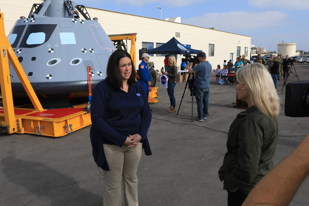 NASA Landing and Recovery Director Melissa Jones briefs the media on the success of Underway Recovery Test-7 on Nov. 7, 2018, at U.S. Naval Base San Diego. Behind her is the test version of the Orion crew module. All of the recovery equipment that was created to safely bring Orion home passed verification and validation testing. The Recovery Team, along with the U.S. Navy, practice recovering the Orion test version as part of URT-7 in the Pacific Ocean. URT-7 is one in a series of tests to verify and validate procedures and hardware that will be used to recover the Orion spacecraft after it splashes down in the Pacific Ocean following deep space exploration missions. Orion will have emergency abort capability, sustain the crew during space travel and provide safe re-entry from deep space return velocities.