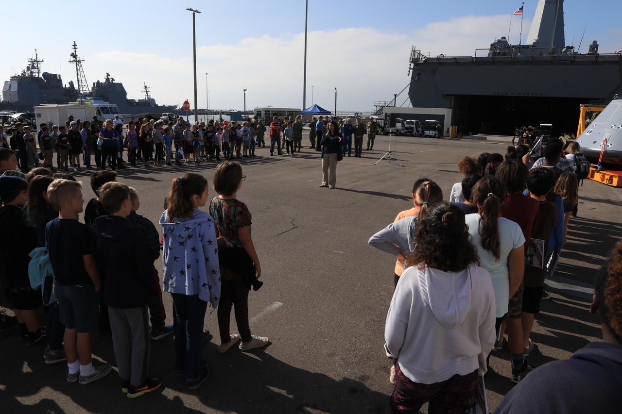 NASA Landing and Recovery Director Melissa Jones talks to students, members of the media and the general public about the success of Underway Recovery Test-7 on Nov. 7, 2018, at U.S. Naval Base San Diego. All of the recovery equipment that was created to safely bring Orion home passed verification and validation testing. The Recovery Team, along with the U.S. Navy, practice recovering the Orion test version as part of URT-7 in the Pacific Ocean. URT-7 is one in a series of tests to verify and validate procedures and hardware that will be used to recover the Orion spacecraft after it splashes down in the Pacific Ocean following deep space exploration missions. Orion will have emergency abort capability, sustain the crew during space travel and provide safe re-entry from deep space return velocities.