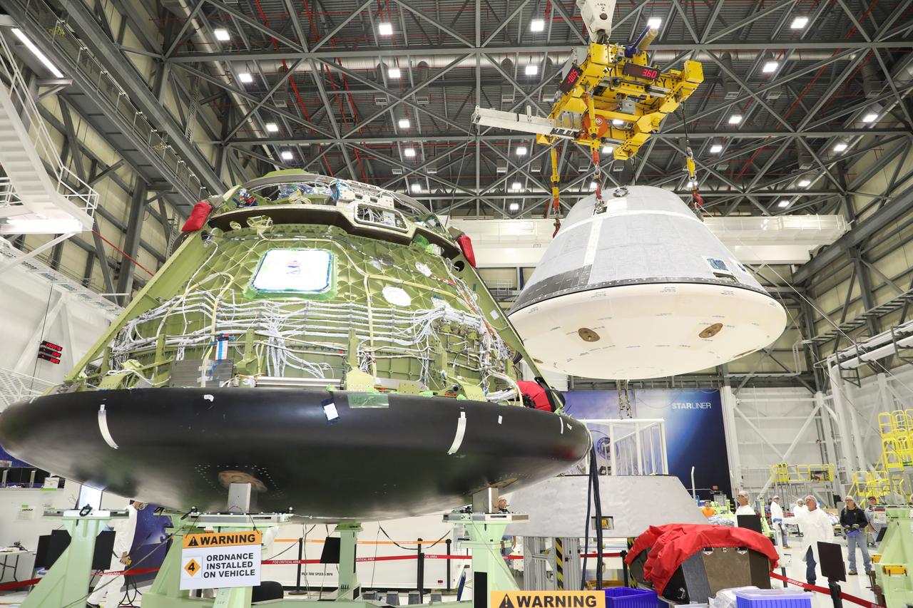 Seen in the foreground inside the Commercial Crew and Cargo Processing Facility (C3PF) at NASA's Kennedy Space Center in Florida on Nov. 11, 2018, the spacecraft destined to fly astronauts to the International Space Station in Boeing's Crew Flight Test (CFT) is prepared for transport to the company's testing facilities in El Segundo, California. The company's CST-100 Starliner will be undergoing a series of environmental tests designed to simulate what the spacecraft will experience during different stages of flight as part of NASA's Commercial Crew Program (CCP). The agency's CCP will return human spaceflight launches to U.S. soil, providing safe, reliable and cost-effective access to low-Earth orbit on systems that meet our safety and mission requirements.
