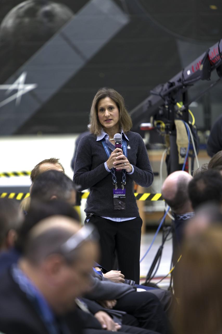 During a "Powering Exploration Mission-1" ceremony in the Neil Armstrong Operations and Checkout Building high bay at NASA's Kennedy Space Center on Nov. 16, 2018, Amy Marasia, Orion Crew Module assembly lead for Exploration Mission-1 (EM-1), explains the next steps in processing Orion and the European Service Module (ESM). The event was held to mark a major milestone, the arrival of the European Service Module for Orion's Exploration Mission-1. The service module, built by the European Space Agency, will supply the main propulsion system and power to the Orion spacecraft during EM-1, a mission to the Moon. The ESM also will house air and water for astronauts on future missions. EM-1 will be an uncrewed flight test that will provide a foundation for human deep space exploration to destinations beyond Earth orbit. EM-1 will be the first integrated test of NASA's Space Launch System, Orion and the ground systems at Kennedy.