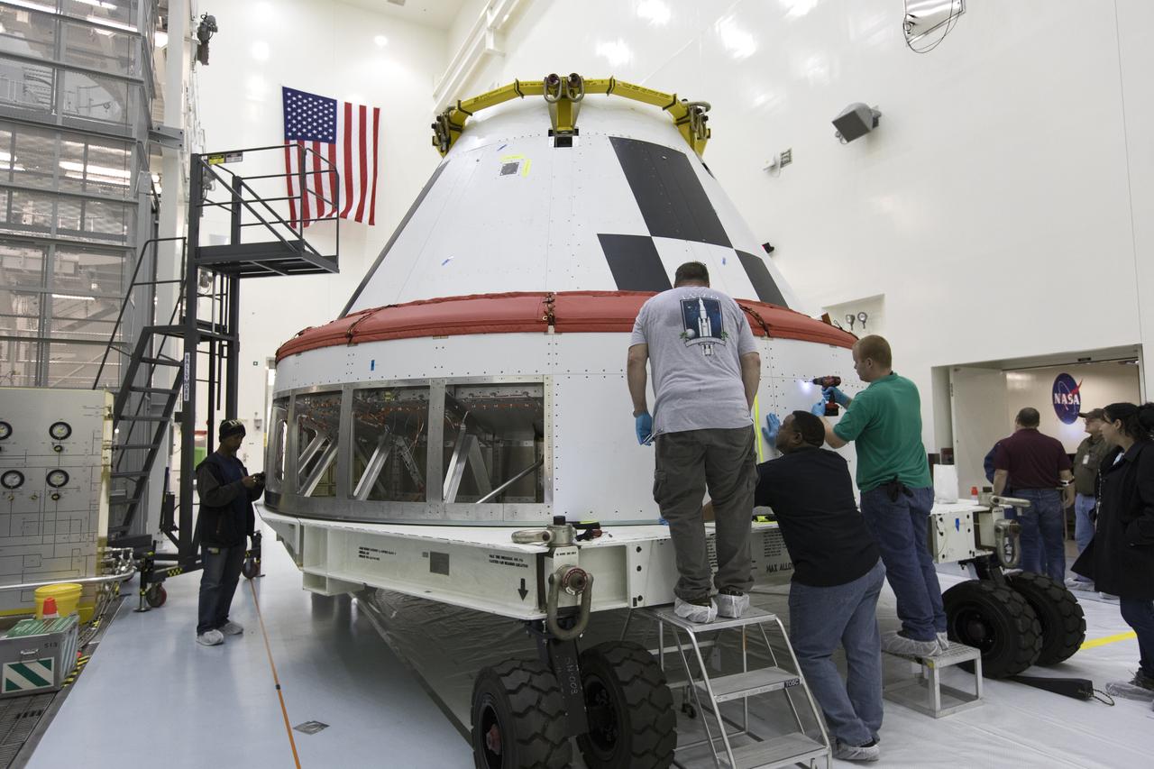 Workers remove cover plates from a mock Orion crew module inside the Multi-Payload Processing Facility at NASA’s Kennedy Space Center in Florida on Dec. 6, 2018. The crew module will be used during a full stress test of the Launch Abort System (LAS), called Ascent Abort-2 (AA-2), scheduled for April 2019. During the test, the Northrop Grumman booster will launch from Space Launch Complex 46, carrying a fully functional LAS and the 22,000-pound Orion test vehicle to an altitude of 31,000 feet and traveling at more than 1,000 miles an hour. The test will verify the LAS can steer the crew module and astronauts aboard to safety in the event of an issue with the Space Launch System (SLS) rocket when the spacecraft is under the highest aerodynamic loads it will experience during a rapid climb into space.