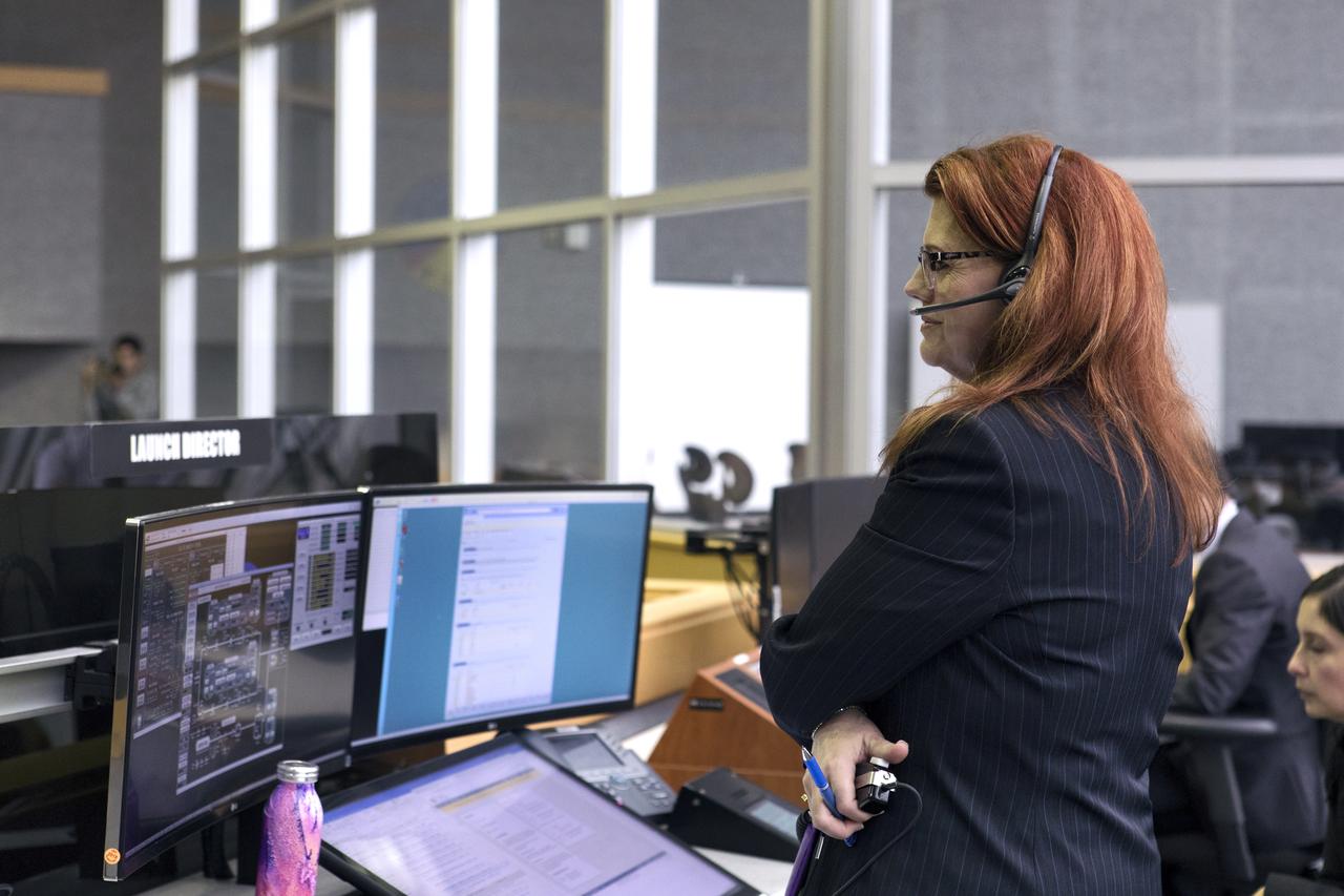 NASA Launch Director Charlie Blackwell-Thompson stands next to her console in Firing Room 1 at the Kennedy Space Center's Launch Control Center during a terminal countdown demonstration for Exploration Mission 1, or EM-1. The launch will be the first integrated test of the Space Launch System rocket and Orion spacecraft that will eventually take astronauts beyond low-Earth orbit to destinations such as the Moon and Mars. Taking place on Dec. 14, 2018, the countdown demonstration was intended to validate the launch team's capability to perform an EM-1 countdown and respond to challenges put into the system for practice.