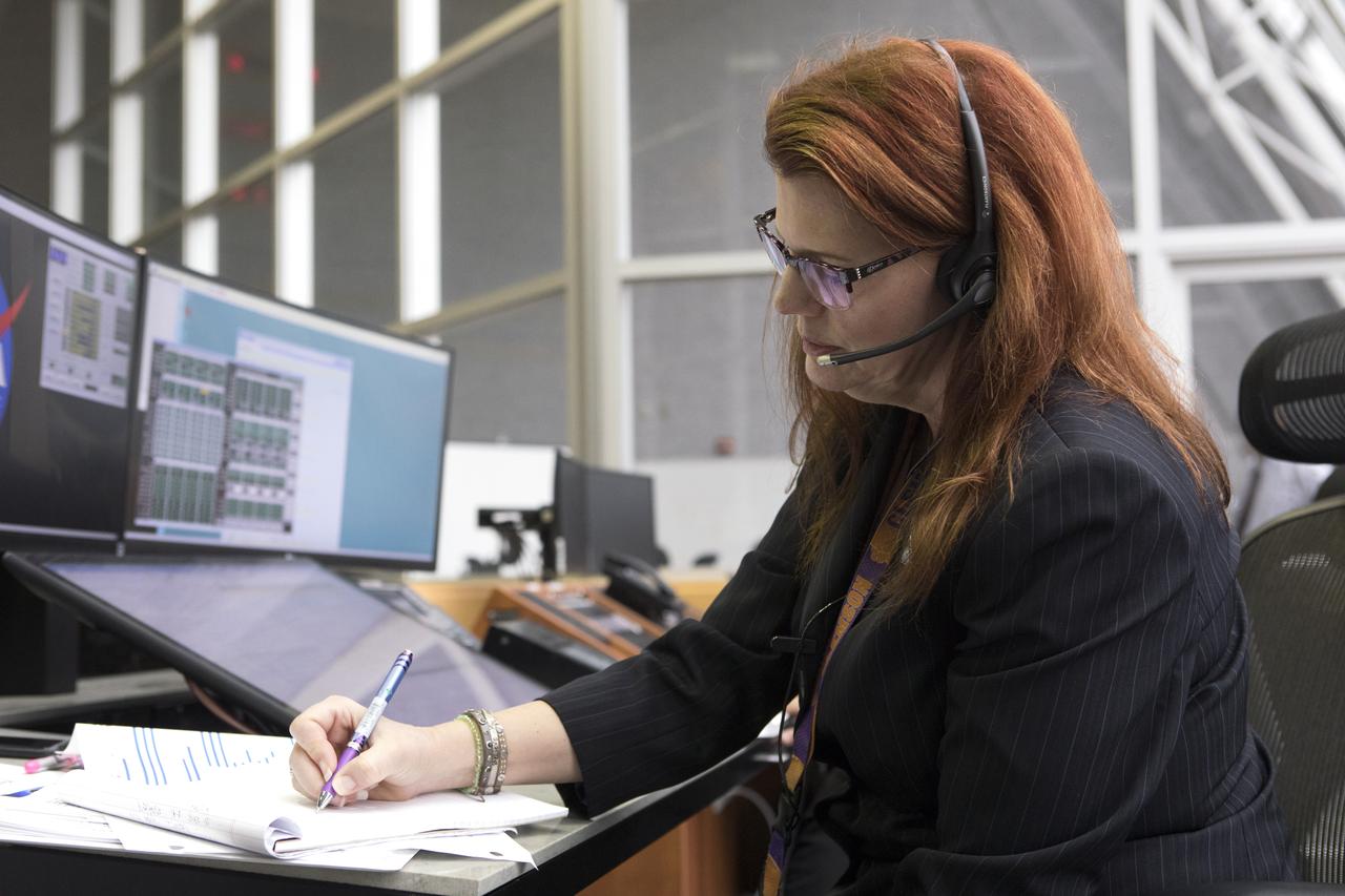 NASA Launch Director Charlie Blackwell-Thompson makes notes at her console in Firing Room 1 at the Kennedy Space Center's Launch Control Center during a terminal countdown demonstration for Exploration Mission 1, or EM-1. The launch will be the first integrated test of the Space Launch System rocket and Orion spacecraft that will eventually take astronauts beyond low-Earth orbit to destinations such as the Moon and Mars. Taking place on Dec. 14, 2018, the countdown demonstration was intended to validate the launch team's capability to perform an EM-1 countdown and respond to challenges put into the system for practice.