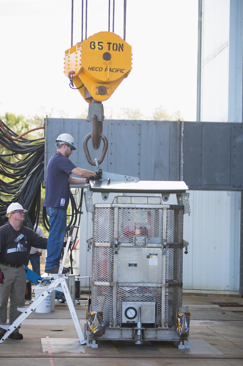 Technicians attach a crane to a test version of the Multi-Mission Radioisotope Thermoelectric Generator (MMRTG) for NASA’s Mars 2020 mission at the United Launch Alliance Vertical Integration Facility (VIF) at Space Launch Complex 41 at Cape Canaveral Air Force Station in Florida on Feb. 15, 2019. The MMRTG simulator will be used to practice operations and procedures for carefully hoisting it up and into the VIF. The Mars 2020 rover mission is targeted to launch in July 2020 on a ULA Atlas V rocket from Pad 41. Mars 2020 is part of NASA’s Mars Exploration Program, a long-term effort of robotic exploration of the Red Planet. The rover will search for habitable conditions in the ancient past and signs of past microbial life on Mars.