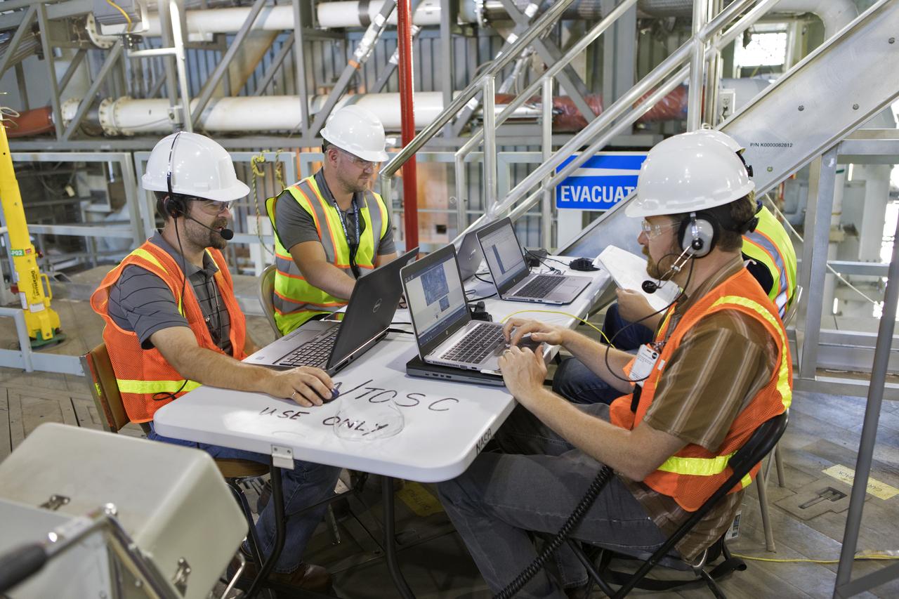 Technicians and engineers with Jacobs on the Test and Operations Support Contract, prepare for a swing test of the Core Stage Inter-tank Umbilical (CSITU) on the mobile launcher in High Bay 3 of the Vehicle Assembly Building on Feb. 22, 2019, at NASA's Kennedy Space Center in Florida. The CSITU is a swing-arm umbilical that will connect to the Space Launch System core stage inter-tank. It will provide conditioned air, pressurized gases and power and data connection to the core stage. Exploration Ground Systems at Kennedy is conducting the swing test.
