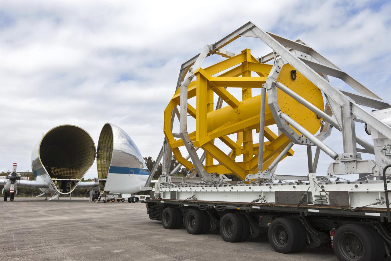 A fit check of the Orion Crew and Service Module Horizontal Transporter (CHT) with NASA's Super Guppy aircraft began March 12, 2019, at NASA Kennedy Space Center’s Shuttle Landing Facility in Florida, operated by Space Florida. In this photo, the Super Guppy’s payload bay is opened as the CHT, secured on the U.S. Air Force aircraft loader, is moved toward the aircraft. The fit check is being performed to confirm loading operations, ensure that the CHT fits inside the Super Guppy and test the electrical interface to aircraft power. The Orion crew and service modules will be readied for a trip to NASA’s Plum Brook Station in Sandusky, Ohio, for full thermal vacuum testing. In this unique facility, the crew and service modules will be put through extensive testing to ensure they can survive the rigors of launch, space travel, re-entry and splashdown. The Orion spacecraft will launch atop the agency's Space Launch System rocket on Exploration Mission-1. 