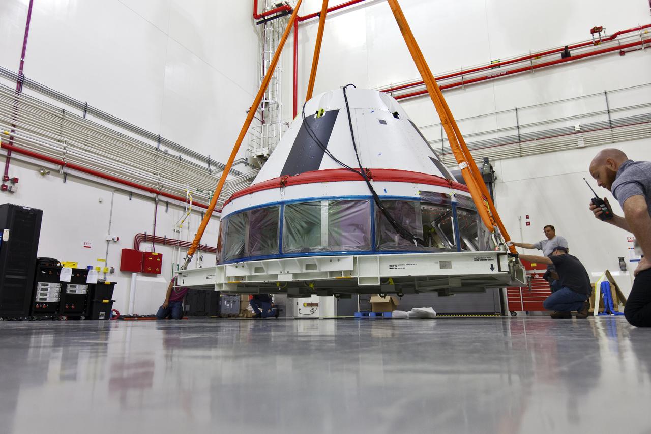 Inside the Launch Abort System Facility (LASF) at NASA’s Kennedy Space Center in Florida, workers attach a crane to a test version of the Orion crew module on March 13, 2019. The Orion test module and the Launch Abort System will be used for the Orion Ascent Abort-2 (AA-2) Flight Test, a full-stress test of the LAS, scheduled for spring 2019. AA-2 will launch from Space Launch Complex 46, carrying a fully functional LAS and a 22,000-pound Orion test vehicle to an altitude of 31,000 feet and traveling at more than 1,000 miles an hour. The test will verify the LAS can steer the crew module and astronauts aboard to safety in the event of an issue with the Space Launch System (SLS) rocket when the spacecraft is under the highest aerodynamic loads it will experience during a rapid climb into space. NASA's Orion and Exploration Ground Systems programs and contractors from Jacob's and Northrop Grumman in conjunction with the Air Force Space and Missile Center's Launch Operations branch are performing flight operations for AA-2.