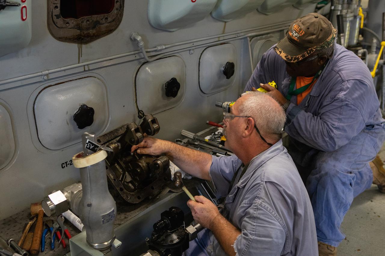 William Vardaman, left, and Pat Brown, mechanical technicians with the Jacobs contracting team, perform engine maintenance on NASA's crawler-transporter 2 on March 26, 2019, in the crawler yard located in Kennedy Space Center's Launch Complex 39 area. Recent engine work included rebuilding the vehicles’ fuel pump assemblies and installing new oil pumps that will help minimize future wear. This is one of two crawler-transporters that carried rockets and spacecraft, including the Apollo/Saturn V and space shuttle, from the Vehicle Assembly Building to the launch pad. NASA’s Exploration Ground Systems oversaw modifications and upgrades to crawler-transporter 2 so it can carry the mobile launcher and NASA's Space Launch System rocket, topped by the Orion spacecraft, to Launch Pad 39B for Exploration Mission-1.