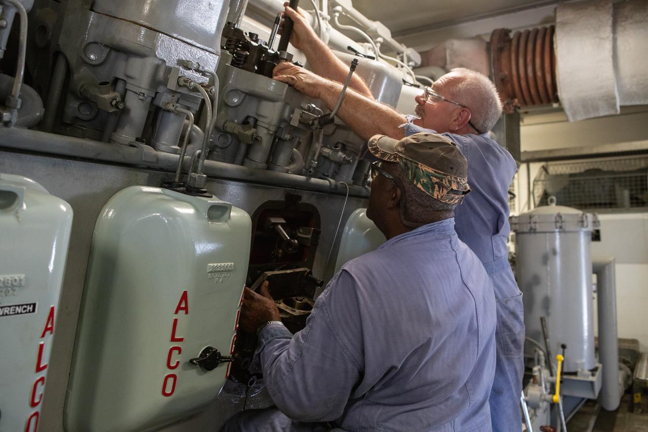 Pat Brown, left, and William Vardaman, mechanical technicians with the Jacobs contracting team, perform engine maintenance on NASA's crawler-transporter 2 on March 26, 2019, in the crawler yard located in Kennedy Space Center's Launch Complex 39 area. Recent engine work included rebuilding the vehicles’ fuel pump assemblies and installing new oil pumps that will help minimize future wear. This is one of two crawler-transporters that carried rockets and spacecraft, including the Apollo/Saturn V and space shuttle, from the Vehicle Assembly Building to the launch pad. NASA’s Exploration Ground Systems oversaw modifications and upgrades to crawler-transporter 2 so it can carry the mobile launcher and NASA's Space Launch System rocket, topped by the Orion spacecraft, to Launch Pad 39B for Exploration Mission-1.