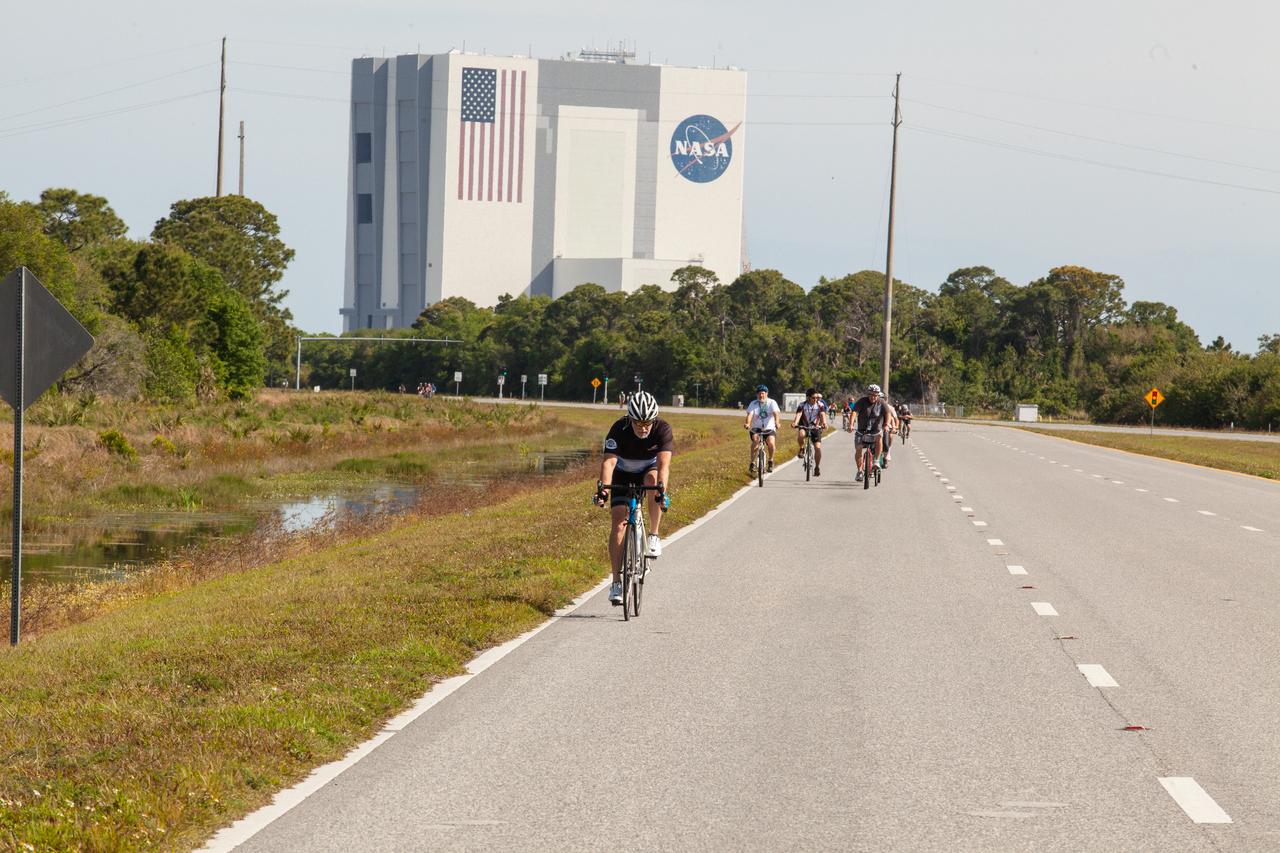 Cyclists pedal away from the Vehicle Assembly Building (VAB), continuing on Kennedy Space Center’s annual Tour de KSC. The bicycle tour took place March 30, giving Kennedy employees and guests the opportunity to choose from three different routes that ranged from seven to 33 miles along some of the Florida spaceport’s most notable facilities such as the VAB, the Shuttle Landing Facility and historic Launch Pad 39A, among others. 