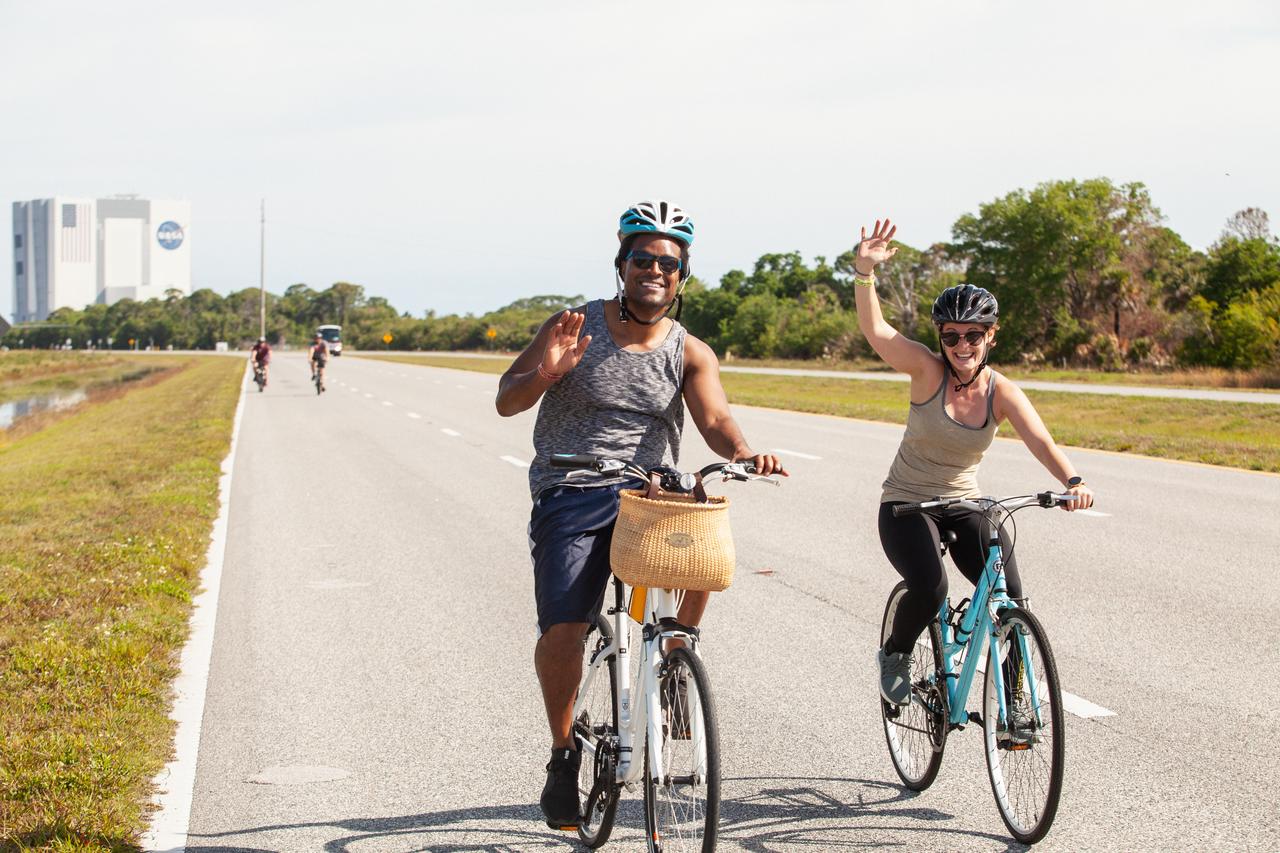 Cyclists wave as they pass by during Kennedy Space Center’s annual Tour de KSC. The bicycle tour took place March 30, giving Kennedy employees and guests the opportunity to choose from three different routes that ranged from seven to 33 miles along some of the Florida spaceport’s most notable facilities such as the VAB, the Shuttle Landing Facility and historic Launch Pad 39A, among others. 