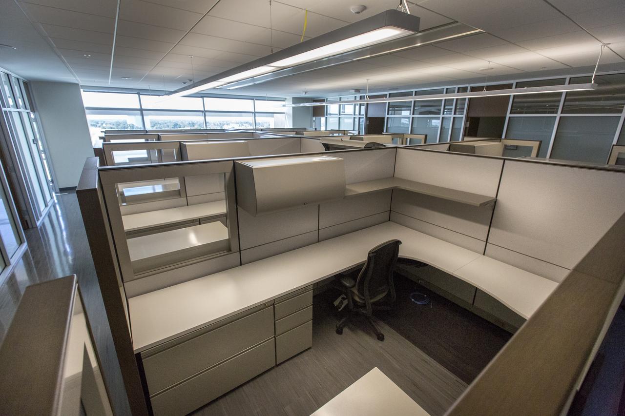 A view of some of the work stations in the new headquarters building on April 3, 2019, at NASA’s Kennedy Space Center in Florida. The newly constructed facility anchors the multi-user spaceport’s Central Campus. More than 500 civil service and contractor employees will be based in the 200,000-square-foot building. The facility earned the U.S. Green Building Council’s Leadership in Energy and Environmental Design (LEED) Gold designation. Features include LED lighting throughout, along with occupancy sensors to turn off unneeded lights; windows, screens and shades designed to maximize natural light; chilled beam HVAC technology reducing the need for ductwork, and more.