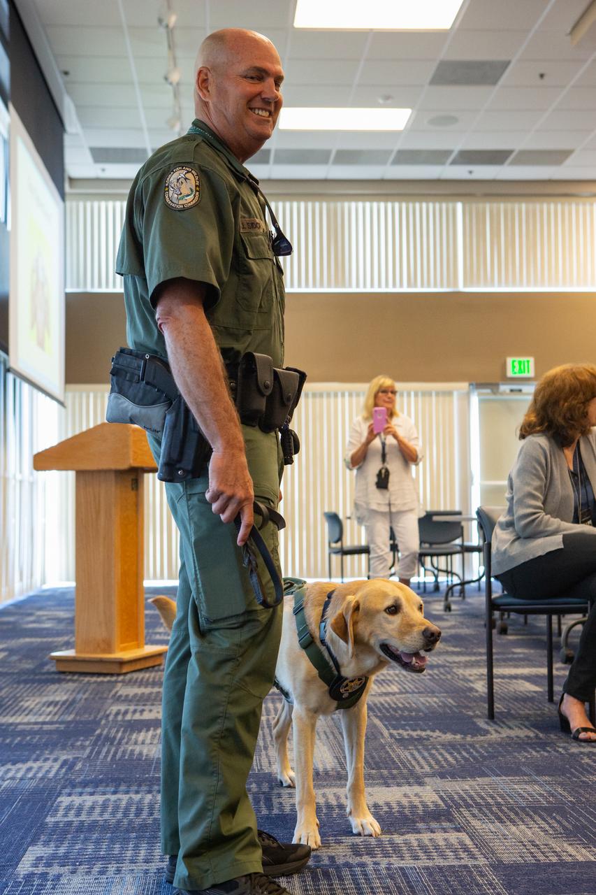 Fish and Wildlife Conservation Commission (FWC) Officer Jeff Sidor presents information on FWC’s Port K9 Program to Kennedy Space Center employees in the Space Station Processing Facility Conference Center on April 23, 2019. Officer Sidor brought a special K9, Harry, to demonstrate how FWC is using specially trained dogs in airports, seaports and mail facilities to detect illegal and invasive fish and wildlife species shipping into Florida. The demonstration involved Harry distinguishing which box, among many, contained a turtle shell. This lunch and learn was available for employees to attend as part of Kennedy’s Earth Day events. 