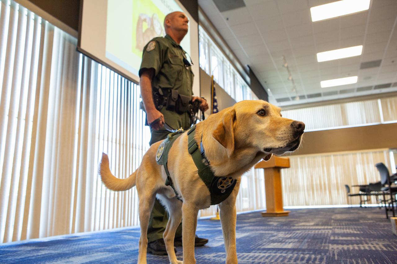 Fish and Wildlife Conservation Commission (FWC) Officer Jeff Sidor presents information on FWC’s Port K9 Program to Kennedy Space Center employees in the Space Station Processing Facility Conference Center on April 23, 2019. Officer Sidor brought a special K9, Harry, to demonstrate how FWC is using specially trained dogs in airports, seaports and mail facilities to detect illegal and invasive fish and wildlife species shipping into Florida. The demonstration involved Harry distinguishing which box, among many, contained a turtle shell. This lunch and learn was available for employees to attend as part of Kennedy’s Earth Day events. 