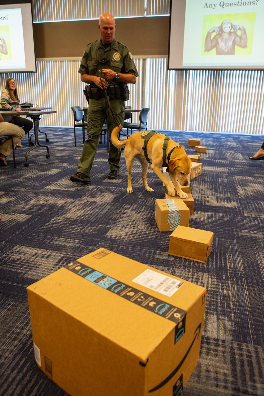 Inside Kennedy Space Center’s Space Station Processing Facility Conference Center, Fish and Wildlife Conservation Commission’s (FWC) Officer Jeff Sidor and K9 Harry demonstrate how specially trained dogs are used to detect illegal and invasive fish and wildlife species shipping into Florida. The demonstration, held April 23, 2019, involved Harry distinguishing which box, among many, contained a turtle shell. Prior to the demonstration, Officer Sidor presented information on FWC’s Port K9 Program to Kennedy employees. This lunch and learn was available for employees to attend as part of Kennedy’s Earth Day events. 