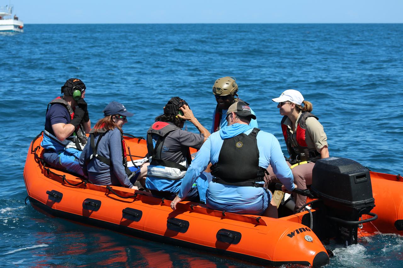 NASA astronauts Suni Williams and Barry “Butch” Wilmore, joined by their training team on a watercraft in the Atlantic Ocean, secure their safety gear as they prepare to rehearse the steps they would take to exit Boeing’s CST-100 Starliner spacecraft without assistance in the unlikely event of an emergency resulting in a splashdown. The training exercise, which occurred April 27, 2019, took place several miles off the coast of Cape Canaveral near NASA’s Kennedy Space Center in Florida. It included the astronauts unloading a rescue raft from inside the spacecraft, climbing out through a hatch at the top of the spacecraft, jumping into the Atlantic Ocean and boarding the raft. This open-ocean exercise provides the astronauts with the necessary training ahead of Boeing’s Crew Flight Test and subsequent missions. During normal return scenarios, Boeing’s Starliner will land in a safe zone of about 15 square miles in the Western United States. Throughout the commercial crew development phases with NASA, Boeing has performed dozens of qualification tests on its parachute and airbag systems simulating conditions on land and in the water. 