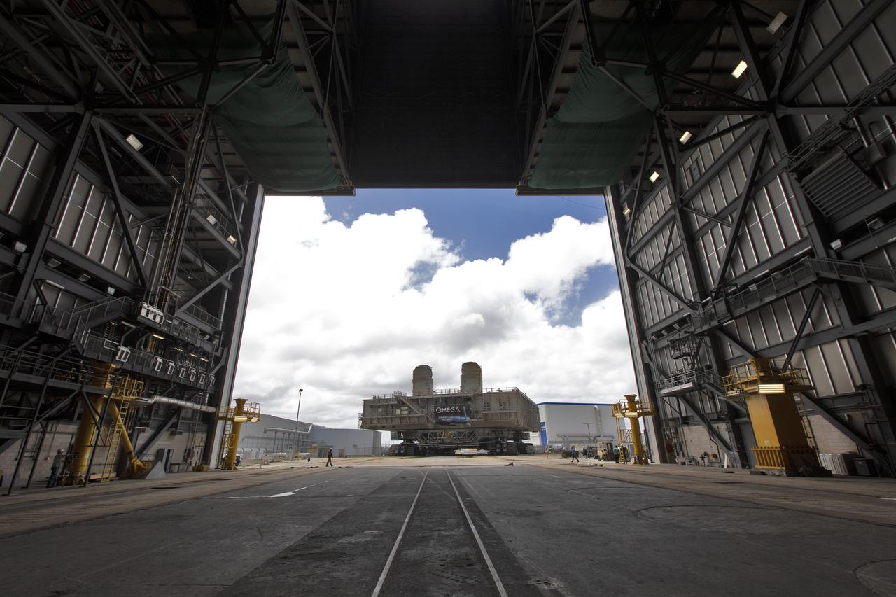 During a practice run, crawler-transporter 2 (CT-2), with the space shuttle-era mobile launch platform-3 (MLP-3) on top, has exited High Bay 2 of the Vehicle Assembly Building (VAB) and moves slowly along the crawlerway at NASA’s Kennedy Space Center in Florida on May 1, 2019. The VAB is getting its first commercial tenant. Northrop Grumman signed a Reimbursable Space Act Agreement with NASA for use of the facilities. The company will assemble and test its new OmegA rocket inside the massive facility’s High Bay 2. The company also will modify MLP-3 to serve as the launch vehicle’s assembly and launch platform. Northrop Grumman is developing the OmegA rocket, an intermediate/heavy-class launch vehicle, as part of a launch services agreement with the U.S. Air Force.