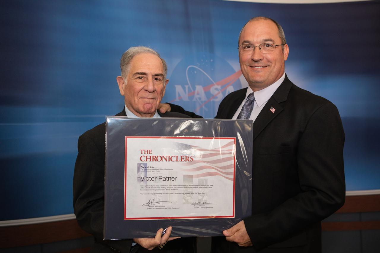 NASA Public Affairs Officer Greg Harland, right, poses for a photograph with newly inducted Chronicler Vic Ratner during a ceremony at Kennedy Space Center’s NASA News Center in Florida on May 3, 2019. Ratner covered the space program for ABC Radio and was the only radio correspondent on the air live during the Space Shuttle Challenger accident, providing on-the-scene information for more than five hours that day after the tragedy. Also inducted as members were journalists Jim Banke and Todd Halvorson, and photographer Peter Cosgrove. They were selected by a committee of their peers on March 25. The Chroniclers recognizes retirees of the news and communications business who have helped spread news of American space exploration from Kennedy for 10 years or more. 
