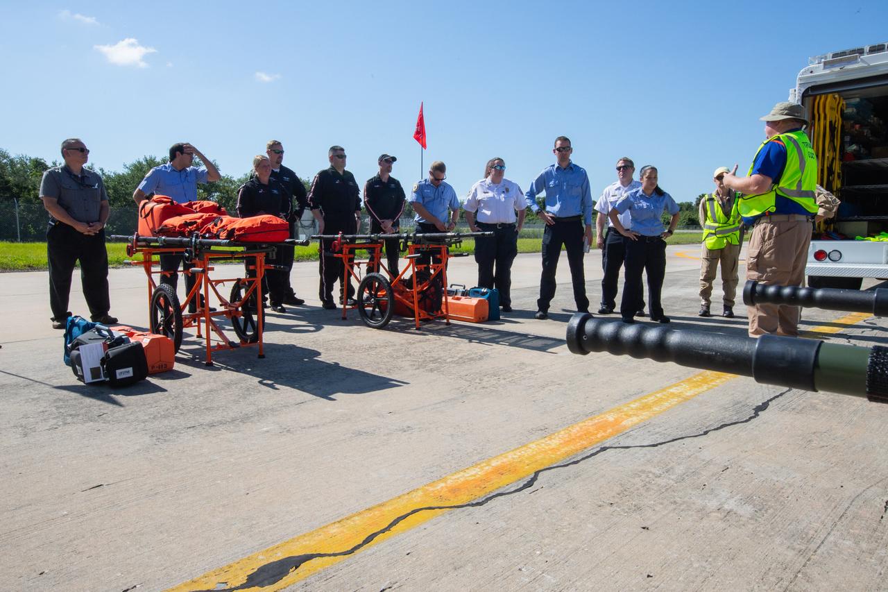 Kennedy Space Center personnel and American Medical Response (AMR) contractor paramedics gather at the Florida spaceport’s Shuttle Landing Facility on May 17, 2019, for a medical support training course. The course was designed to familiarize the AMR paramedics with the center’s Triage Forces deployment, which included medical team members, fire/rescue personnel, environmental health specialists and flight operations crew members, as well as a helicopter, Mine Resistant Ambush Protected (MRAP) tactical vehicle, fire pumper truck and triage vehicles. The AMR paramedics will assist the agency in contingency planning for the return of human spaceflight from Kennedy.