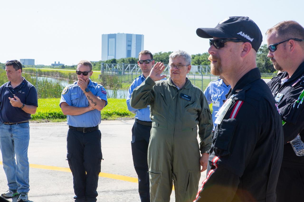 KEMCON physician Dr. Dan Woodard speaks to Kennedy Space Center personnel and American Medical Response (AMR) contractor paramedics gathered at the Florida spaceport’s Shuttle Landing Facility on May 17, 2019, for a medical support training course. The course was designed to familiarize the AMR paramedics with the center’s Triage Forces deployment, which included medical team members, fire/rescue personnel, environmental health specialists and flight operations crew members, as well as a helicopter, Mine Resistant Ambush Protected (MRAP) tactical vehicle, fire pumper truck and triage vehicles. The AMR paramedics will assist the agency in contingency planning for the return of human spaceflight from Kennedy.