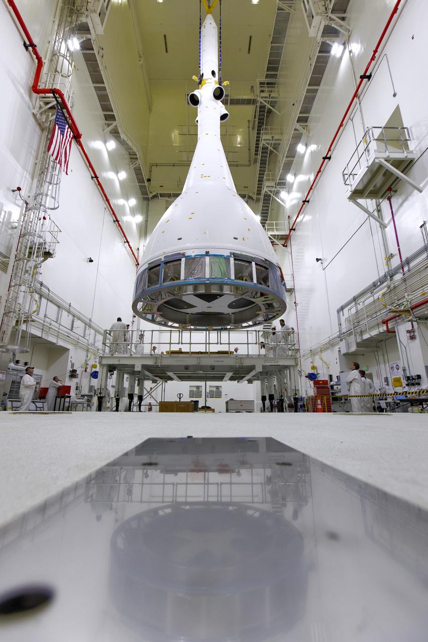 Inside the Launch Abort System Facility (LASF) at NASA’s Kennedy Space Center in Florida, a test version of the Orion crew module has been integrated with the Launch Abort System (LAS) on May 18, 2019. It is being lifted by crane for transfer to a KAMAG transporter. The test vehicle and the LAS will be used for the Orion Ascent Abort-2 (AA-2) Flight Test. AA-2 is a full-stress test of the LAS, planned for July 2. AA-2 will launch from Space Launch Complex 46, carrying a fully functional LAS and a 22,000-pound Orion test vehicle to an altitude of 31,000 feet and traveling at more than 1,000 miles an hour. The test will verify the LAS can steer the crew module and astronauts aboard to safety if an emergency occurs during ascent on the Space Launch System (SLS) rocket. NASA's Orion and Exploration Ground Systems programs, contractors Jacob's, Lockheed Martin and Northrop Grumman, in conjunction with the Air Force Space and Missile Center's Launch Operations branch and the 45th Space Wing are performing flight operations for AA-2.