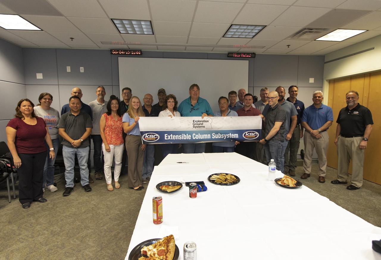 Engineers celebrate the completion of the Extensible Column Subsystem (XCS) project during a banner event held in Operations Support Building II at Kennedy Space Center. The XCS team successfully executed an aggressive schedule, receiving outstanding support from the fabrication contractor, Met-Con. Full functional testing occurred at Met-Con’s facility, with no mechanical or structural issues. All four columns and the test fixture have been delivered to Kennedy. Full-scale testing will take place when the Mobile Launcher gets to the pad later this summer.