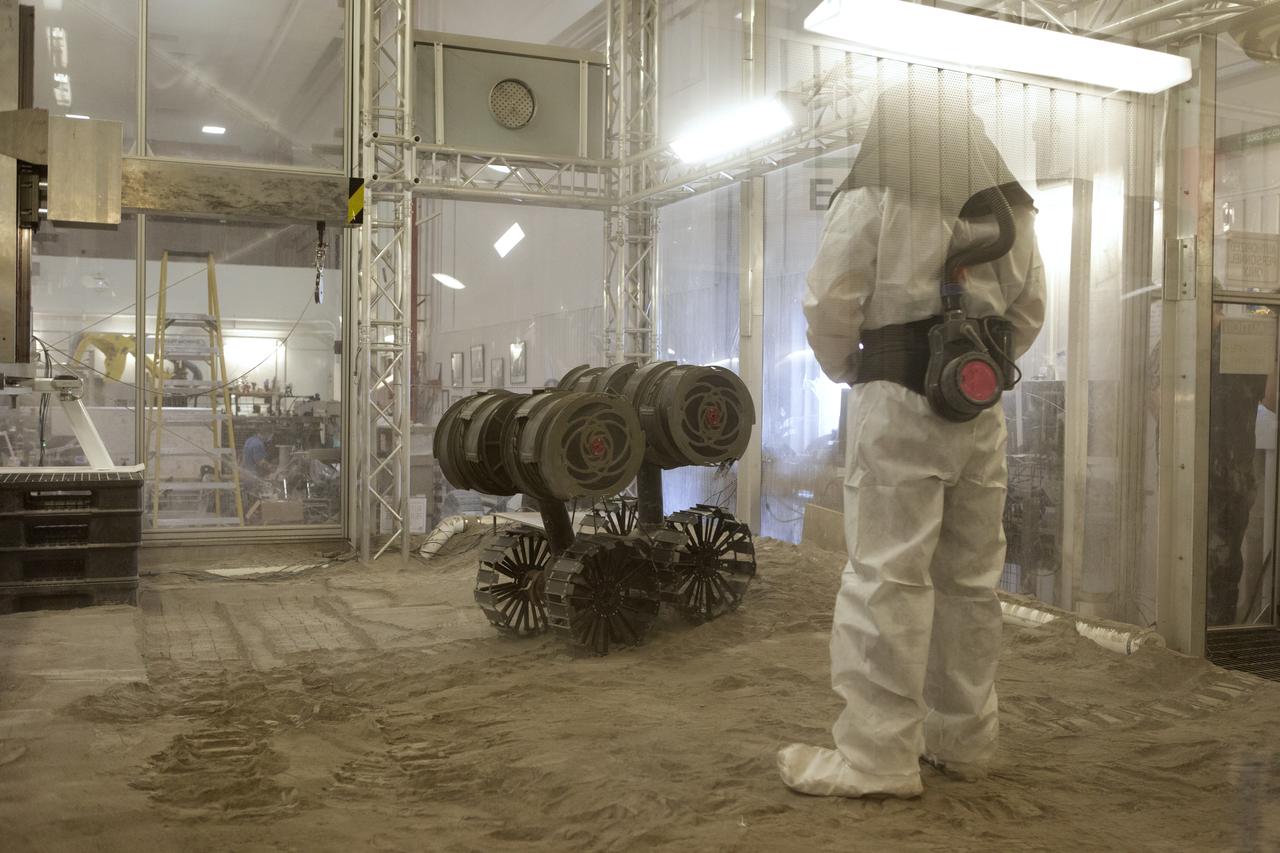 Drew Smith, a robotics engineer, makes adjustments to the Regolith Advanced Surface Systems Operations Robot (RASSOR) during testing in the regolith bin inside Swamp Works at NASA’s Kennedy Space Center in Florida on June 5, 2019. Smith and other members of the Granular Mechanics and Regolith Operations Lab run tests, which simulates the Moon’s reduced gravity using the gravity assist offload system to see how RASSOR excavates regolith. On the surface of the Moon, mining robots like RASSOR will excavate the regolith and take the material to a processing plant where usable elements such as hydrogen, oxygen and water can be extracted for life support systems. RASSOR can scoop up icy regolith which can be used to make operations on the Moon sustainable.