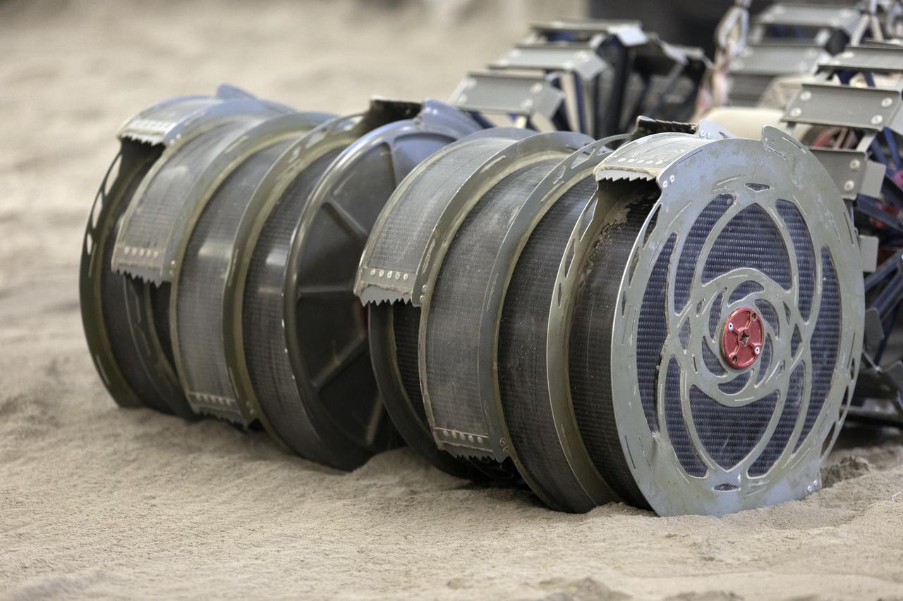 A team from the Granular Mechanics and Regolith Operations Lab tests the Regolith Advanced Surface Systems Operations Robot (RASSOR) in the regolith bin inside Swamp Works at NASA’s Kennedy Space Center in Florida on June 5, 2019. Tests use a gravity assist offload system to simulate reduced gravity conditions found on the Moon. On the surface of the Moon, mining robots like RASSOR will excavate the regolith and take the material to a processing plant where usable elements such as hydrogen, oxygen and water can be extracted for life support systems. RASSOR can scoop up icy regolith which can be used to make operations on the Moon sustainable.