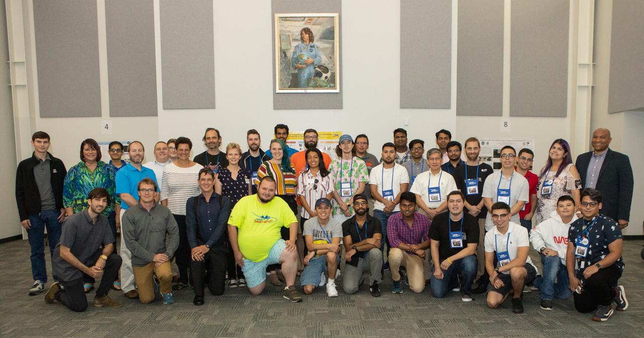 Swarmathon University Competition 2019 organizers, mentors, guest speakers and student teams gather for a group photo on June 11, 2019 at the Kennedy Space Center Visitor Complex in Florida. The University of New Mexico was the host for the physical competition held in May 2019. The student teams were at Kennedy to participate in a student/mentor panel, hear from speakers, get a behind-the-scenes tour of Kennedy Space Center, dine with an astronaut and receive awards during an awards ceremony. During Swarmathon University Challenge IV, students developed algorithms for robotic swarms that are robust and adaptable like the foraging strategies of ant colonies. The fourth and final Swarmathon was a combined virtual and physical competition.