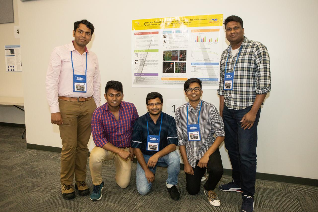 The Swarmathon University Competition 2019 team members from the University of Maryland participate in activities at the Kennedy Space Center Visitor Complex in Florida on June 11, 2019. They are standing in front of a poster they created for the poster competition portion of Swarmathon. The University of New Mexico was the host for the physical competition held in May 2019. The student teams were at Kennedy to participate in a student/mentor panel, hear from speakers, get a behind-the-scenes tour of Kennedy Space Center, dine with an astronaut and receive awards during an awards ceremony. During Swarmathon University Challenge IV, students developed algorithms for robotic swarms that are robust and adaptable like the foraging strategies of ant colonies. The fourth and final Swarmathon was a combined virtual and physical competition.