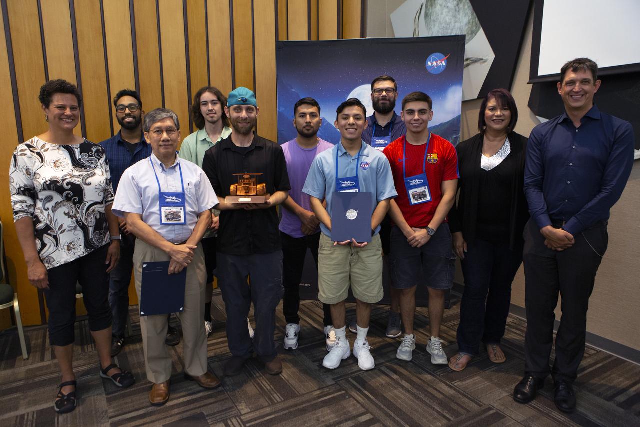 The Swarmathon team from the University of Houston Clearlake and San Jacinto College received the Mission to Mars award for their achievements in the NASA Swarmathon University Challenge for 2019. They are at the Kennedy Space Center Visitor Complex on June 12, 2019. Students and mentors from some of the Swarmathon teams were at Kennedy to participate in a student/mentor panel, hear from speakers, get a behind-the-scenes tour of Kennedy Space Center, dine with an astronaut and receive awards. During Swarmathon University Challenge IV, students developed algorithms for robotic swarms that are robust and adaptable like the foraging strategies of ant colonies. The fourth and final Swarmathon challenge was a combined virtual and physical competition.