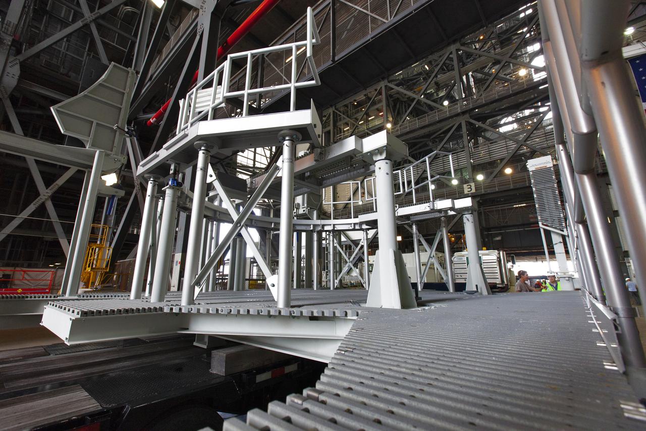 The engine service platform that will provide access to the core stage of the Space Launch System (SLS) rocket is moved beneath the mobile launcher (ML) in High Bay 3 of the Vehicle Assembly Building at NASA’s Kennedy Space Center in Florida on June 14, 2019. The large work platform is designed to provide unrestricted access to the RS-25 engines on the SLS core stage from the ML. The service platform will be used for Artemis 1 and subsequent missions. For Artemis 1, the Orion spacecraft will launch atop the SLS rocket from Launch Pad 39B and begin an approximately three-week mission that will send Orion thousands of miles beyond the Moon. Exploration Ground Systems is overseeing work on the ML.