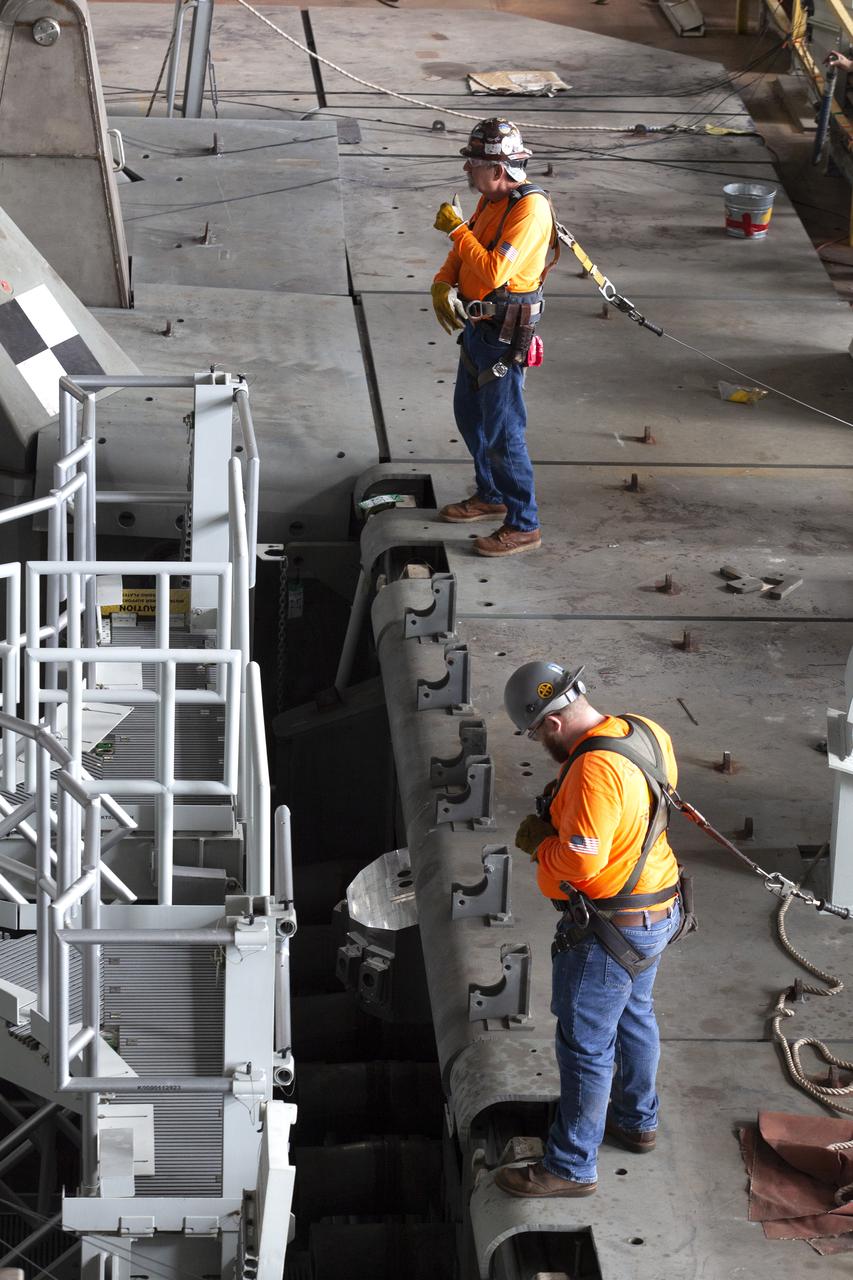 Workers with Bragg Crane and Rigging prepare to assist with the lift of the engine service platform that will provide access to the core stage of the Space Launch System (SLS) rocket on the mobile (ML) in High Bay 3 of the Vehicle Assembly Building at NASA’s Kennedy Space Center in Florida on June 18, 2019. The large work platform is designed to provide unrestricted access to the RS-25 engines on the SLS core stage from the ML. The service platform will be used for Artemis 1 and subsequent missions. For Artemis 1, the Orion spacecraft will launch atop the SLS rocket from Launch Pad 39B and begin an approximately three-week mission that will send Orion thousands of miles beyond the Moon. Exploration Ground Systems is overseeing work on the ML.