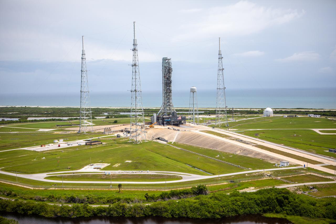 An aerial view of Launch Complex 39B with Exploration Ground Systems’ mobile launcher for the Artemis 1 mission on the pad. The mobile launcher, atop crawler-transporter 2, made its final solo trek from the Vehicle Assembly Building on June 27, 2019, and arrived on the surface of pad B on June 28, 2019, at NASA’s Kennedy Space Center in Florida. The mobile launcher will remain at the pad over the summer, undergoing final testing and checkouts. Its next roll to the pad will be with the agency’s Space Launch System rocket and Orion spacecraft in preparation for the launch of Artemis 1.