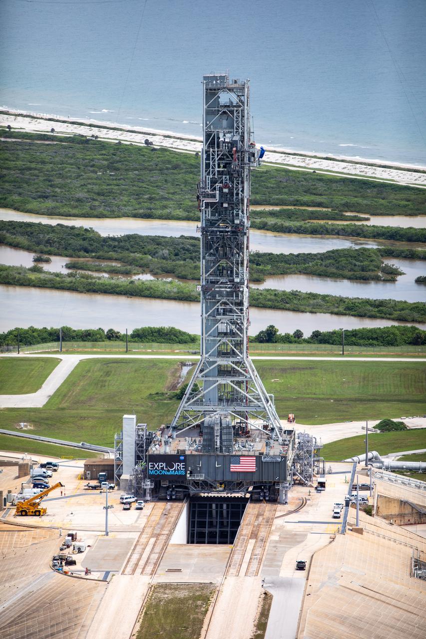 An aerial view of Launch Complex 39B with Exploration Ground Systems’ mobile launcher for the Artemis 1 mission on the pad. The mobile launcher, atop crawler-transporter 2, made its final solo trek from the Vehicle Assembly Building on June 27, 2019, and arrived on the surface of pad B on June 28, 2019, at NASA’s Kennedy Space Center in Florida. The mobile launcher will remain at the pad over the summer, undergoing final testing and checkouts. Its next roll to the pad will be with the agency’s Space Launch System rocket and Orion spacecraft in preparation for the launch of Artemis 1.