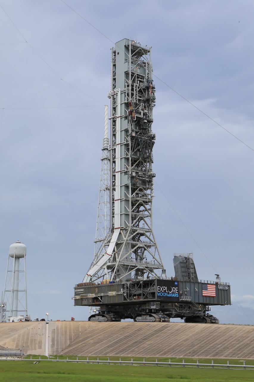 After successfully arriving at Kennedy Space Center’s Launch Complex 39B, Exploration Ground Systems’ mobile launcher is photographed at the pad surface atop crawler-transporter 2 on June 28, 2019. The mobile launcher began its final solo trek to the pad at midnight on June 27, departing from NASA’s Vehicle Assembly Building. The mobile launcher will remain at the pad over the summer, undergoing final testing and checkouts. Its next roll to the pad will be with the agency’s Space Launch System rocket and Orion in preparation for the launch of Artemis 1.