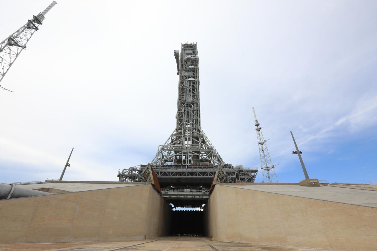 In this view from the flame trench at Kennedy Space Center’s Launch Complex 39B in Florida, Exploration Ground Systems’ mobile launcher can be seen on the pad surface on June 28, 2019. The mobile launcher began its final solo trek – atop crawler-transporter 2 – to the pad at midnight on June 27, departing from NASA’s Vehicle Assembly Building and continuing up to the pad surface on June 28. The mobile launcher will remain at the pad over the summer, undergoing final testing and checkouts. Its next roll to the pad will be with the agency’s Space Launch System rocket and Orion in preparation for the launch of Artemis 1.