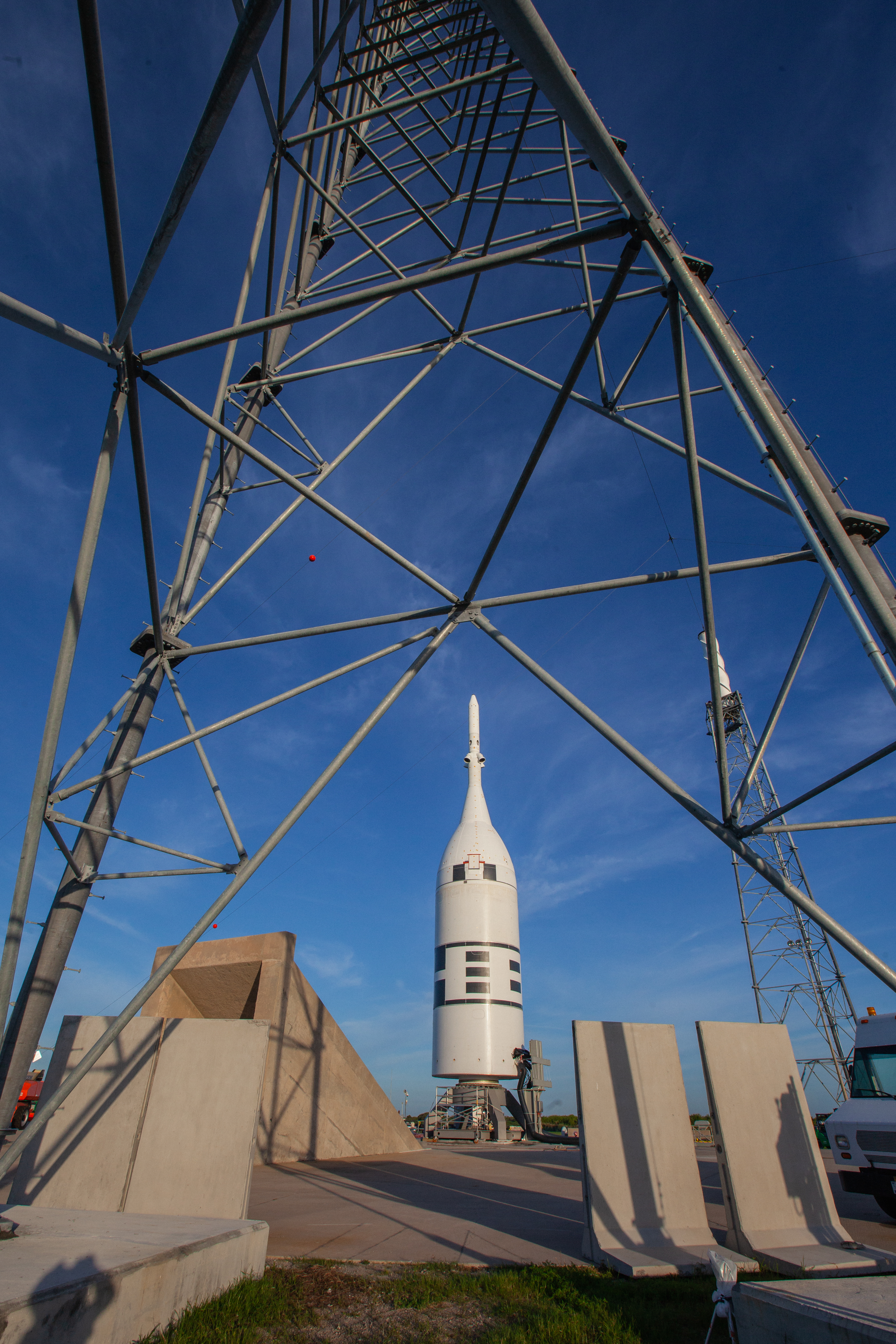 With a view of a lightning tower in the foreground, the Ascent Abort-2 test vehicle is in view on the pad at Launch Complex 46 at Cape Canaveral Air Force Station in Florida after rollback of the vertical integration facility on July 1, 2019. A fully functional Launch Abort System (LAS) mated to a test version of the Orion spacecraft are on a Northrop Grumman provided booster on the pad for launch on NASA’s AA-2 flight test on July 2, 2019. During AA-2, the booster will send the LAS and Orion to an altitude of 31,000 feet, traveling at more than 1,000 mph. The LAS’ three motors will work together to pull the crew module away from the booster and prepare it for splashdown in the Atlantic Ocean. The flight test will prove that the abort system can pull crew to safety in the unlikely event of an emergency during ascent.