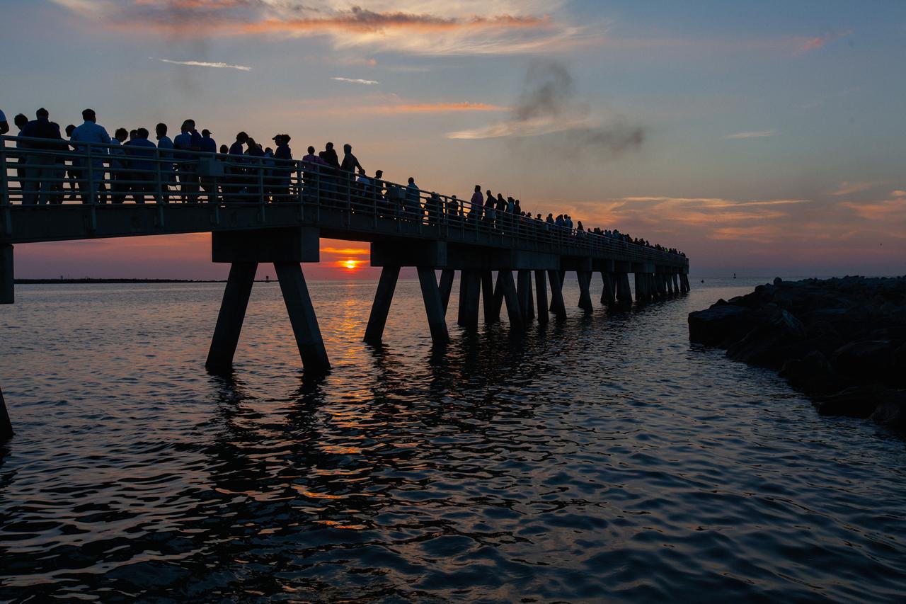 Crowds of spectators watch from Jetty Park in Cape Canaveral, Florida, on July 2, 2019, as a Northrop Grumman provided booster launches from Launch Pad 46 carrying, a fully functional Launch Abort System with a test version of Orion attached for NASA’s Ascent Abort-2 (AA-2). Launch time was 7 a.m. EDT. During AA-2, the booster will send the LAS and Orion to an altitude of 31,000 feet, traveling at Mach 1.15 (more than 1,000 mph). The LAS’ three motors will work together to pull the crew module away from the booster and prepare it for splashdown in the Atlantic Ocean. The flight test will prove that the abort system can pull crew to safety in the unlikely event of an emergency during ascent.