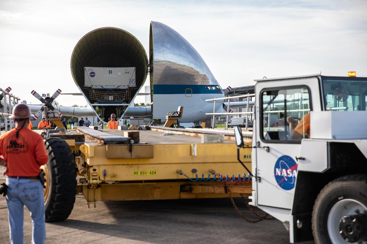 Preparations are underway to unload the heat shield for Orion’s Artemis 2 mission, NASA’s first crewed mission, in its shipping container from NASA’s Super Guppy aircraft at the agency’s Kennedy Space Center Shuttle Landing Facility in Florida on July 9, 2019. The heat shield, measuring roughly 16 feet in diameter, will protect astronauts upon re-entry on the second mission of Artemis. The heat shield arrived from Lockheed Martin’s manufacturing facility near Denver. It will be delivered to the Neil Armstrong Operations and Checkout facility high bay. The heat shield is a base titanium truss structure. Over the next several months, technicians will apply Avcoat, an ablative material that will provide the thermal protection. Artemis 2 will confirm all of the spacecraft’s systems operate as designed in the actual environment of deep space with astronauts aboard.