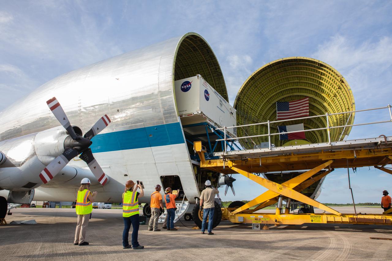 Preparations are underway to unload the heat shield for Orion’s Artemis 2 mission, NASA’s first crewed mission, in its shipping container from NASA’s Super Guppy aircraft at the agency’s Kennedy Space Center Shuttle Landing Facility in Florida on July 9, 2019. The heat shield, measuring roughly 16 feet in diameter, will protect astronauts upon re-entry on the second mission of Artemis. The heat shield arrived from Lockheed Martin’s manufacturing facility near Denver. It will be delivered to the Neil Armstrong Operations and Checkout facility high bay. The heat shield is a base titanium truss structure. Over the next several months, technicians will apply Avcoat, an ablative material that will provide the thermal protection. Artemis 2 will confirm all of the spacecraft’s systems operate as designed in the actual environment of deep space with astronauts aboard.