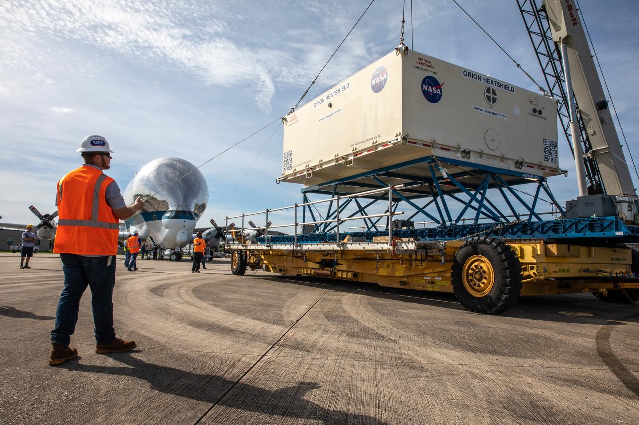 The shipping container carrying the heat shield for Orion’s Artemis 2 mission, NASA’s first crewed mission, is secured onto a transporter at the agency’s Kennedy Space Center Shuttle Landing Facility in Florida on July 9, 2019. The heat shield, measuring roughly 16 feet in diameter, will protect astronauts upon re-entry on the second mission of Artemis. The heat shield arrived from Lockheed Martin’s manufacturing facility near Denver aboard NASA’s Super Guppy Aircraft. It will be delivered to the Neil Armstrong Operations and Checkout facility high bay. The heat shield is a base titanium truss structure. Over the next several months, technicians will apply Avcoat, an ablative material that will provide the thermal protection. Artemis 2 will confirm all of the spacecraft’s systems operate as designed in the actual environment of deep space with astronauts aboard.