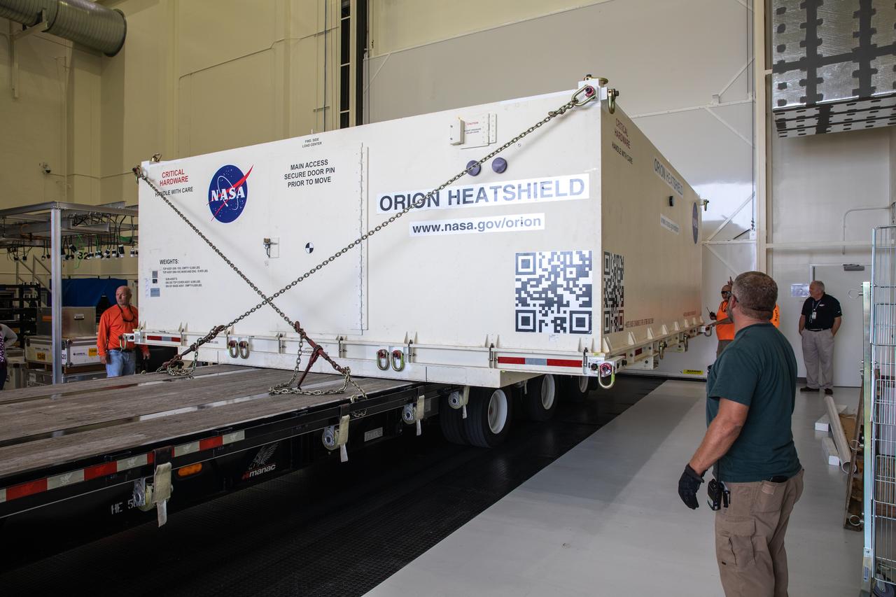 A flatbed truck with the shipping container carrying the heat shield for Orion’s Artemis 2 mission, NASA’s first crewed mission, arrives at the Neil Armstrong Operations and Checkout Building high bay entrance at the agency’s Kennedy Space Center in Florida on July 9, 2019. The heat shield, measuring roughly 16 feet in diameter, will protect astronauts upon re-entry on the second mission of Artemis. The heat shield arrived from Lockheed Martin’s manufacturing facility near Denver aboard NASA’s Super Guppy Aircraft. The heat shield is a base titanium truss structure. Over the next several months, technicians will apply Avcoat, an ablative material that will provide the thermal protection. Artemis 2 will confirm all of the spacecraft’s systems operate as designed in the actual environment of deep space with astronauts aboard.