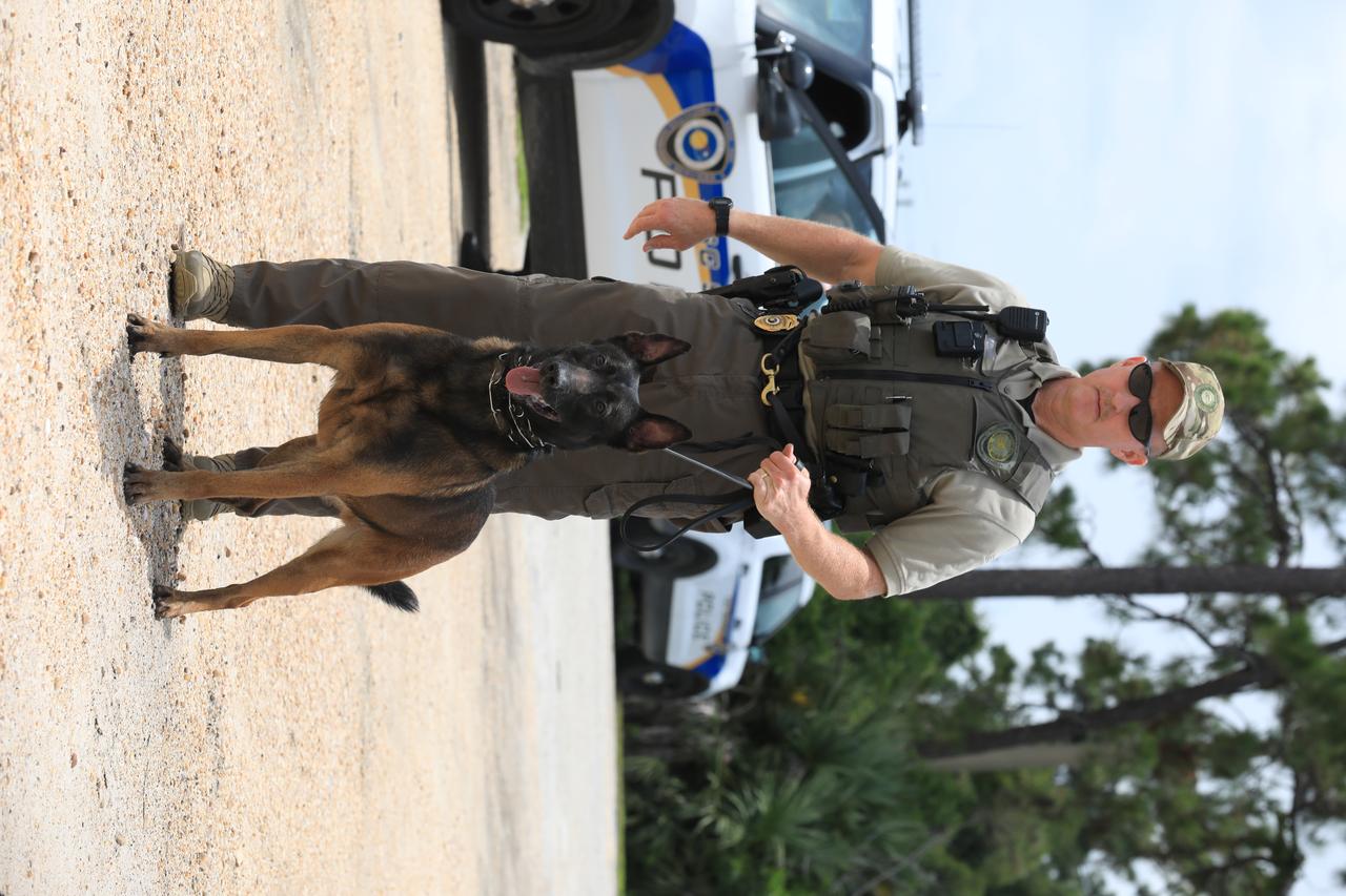 K-9 Spike stands alert and ready for the next training exercise with his Handler Officer John McGee at Kennedy Space Center’s Protective Services Office in Florida on July 10, 2019. The center’s specially trained K-9s support the center 24/7, 365 days. Their main goal is to protect the Kennedy workforce and assets. Normal activities include sweeps of designated facilities, parking lots and random vehicle inspections at entrance gates. During rocket launches, they are out and about performing sweeps of facilities and launch site viewing areas. They cover Kennedy and the Merritt Island National Wildlife Refuge.